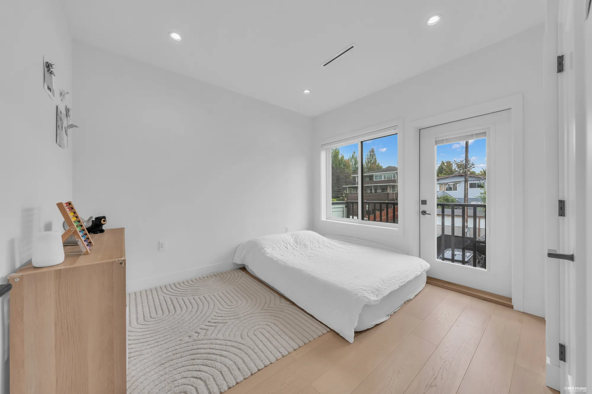 The second bedroom: a bed, a dresser and a glass door to the balcony