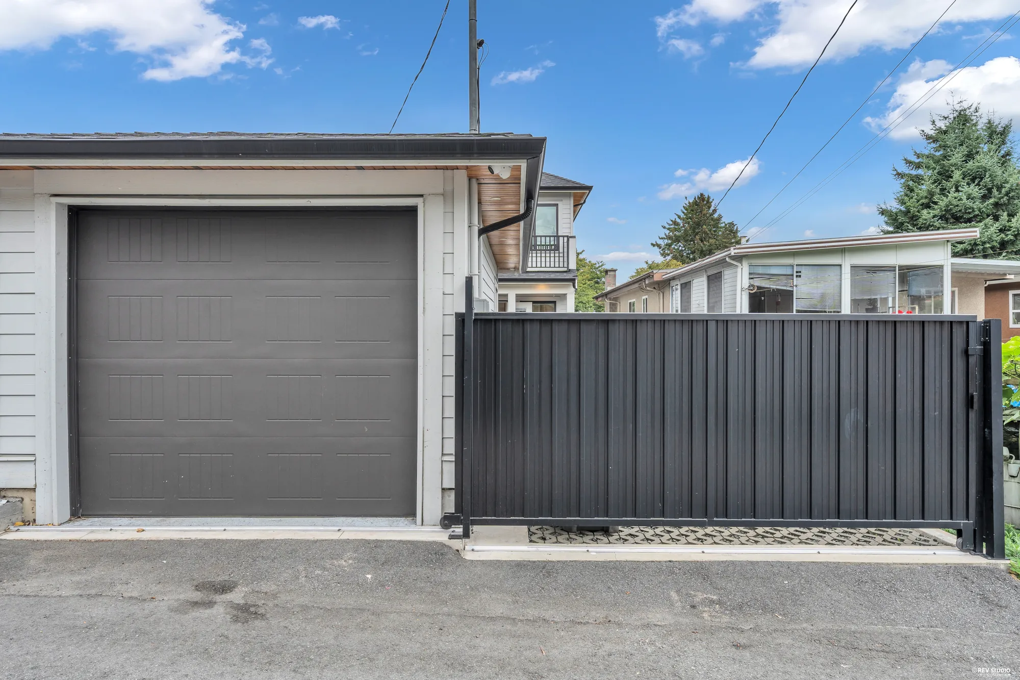 The garage door and the black steel gate from the lane