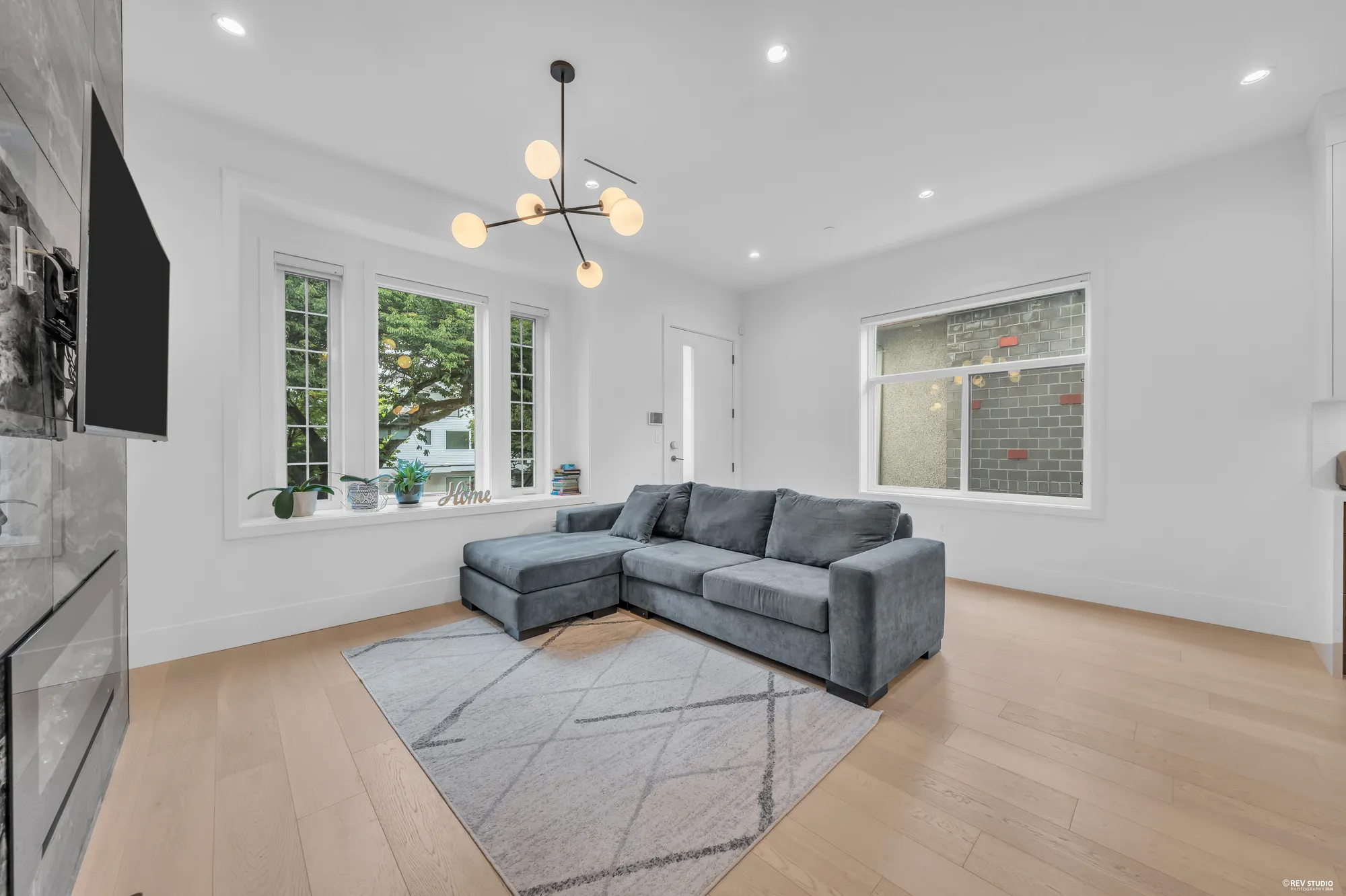 The living room from the fireplace side, the windows onto the street and the front door