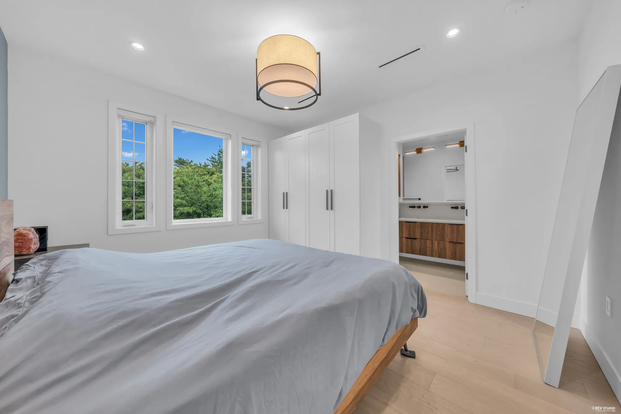 The primary bedroom toward its wardrobe doors and the door to its bathroom