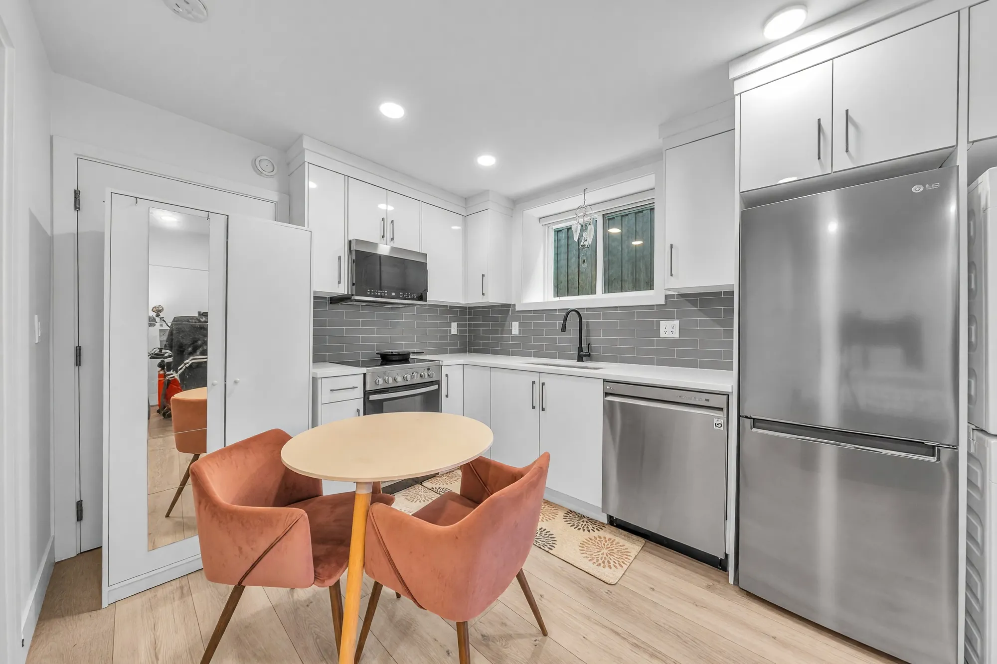 The lower kitchen from the other side: the counter and window, a small round table with two chairs